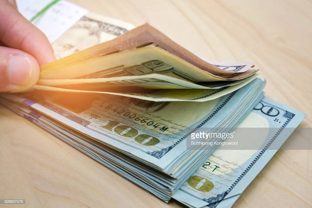 hand-counting-us-dollar-bills-or-paying-in-cash-cash-dollars-lying-on-picture-id826637576.jpg