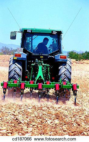 tractor-dragging-a-plough-stock-photograph__cd187066.jpg