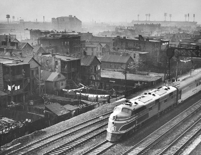 train-moving-past-trackside-tenement-slums.jpg