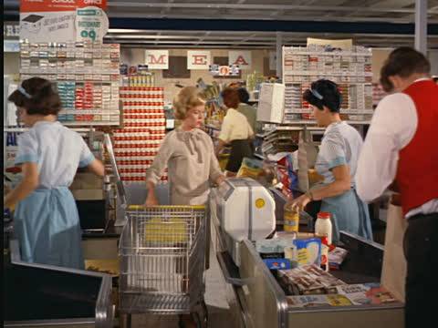 woman-at-checkout-with-cashier-ringing-up-groceries-and-bag-boy-them-video-id561-10?s=640x640.jpg